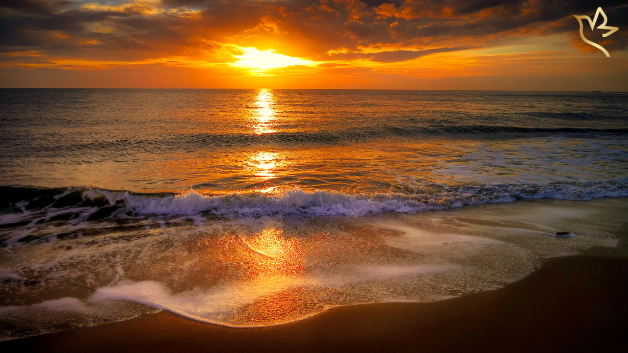 Golden sunset over gentle ocean waves washing onto the shore — symbolizing the ebb and flow of grief, healing, and faith’s calm after emotional storms.