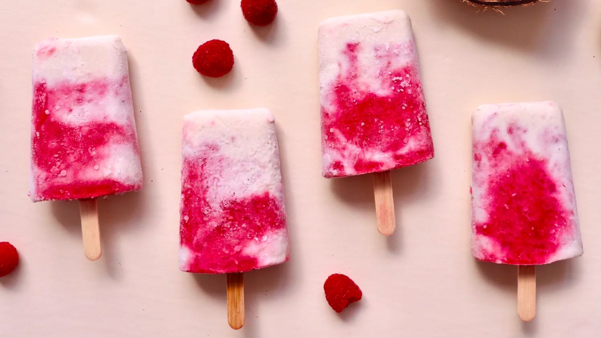 Homemade popsicles with raspberries, coconut, and dragonfruit for cooling relief.