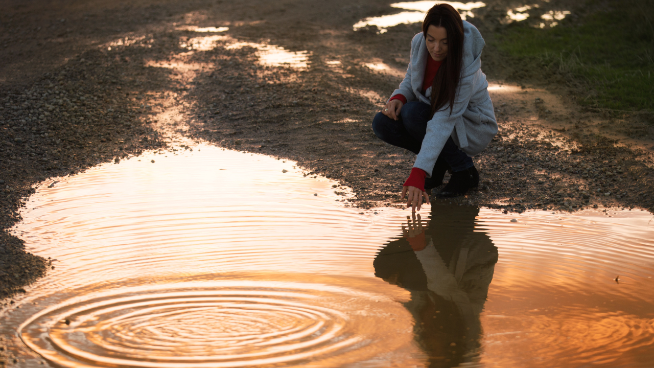 woman touching water ripples
