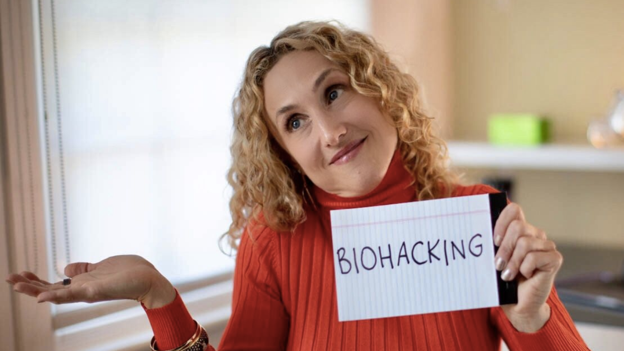 Kristin Weitzel holding a sign that says Biohacking