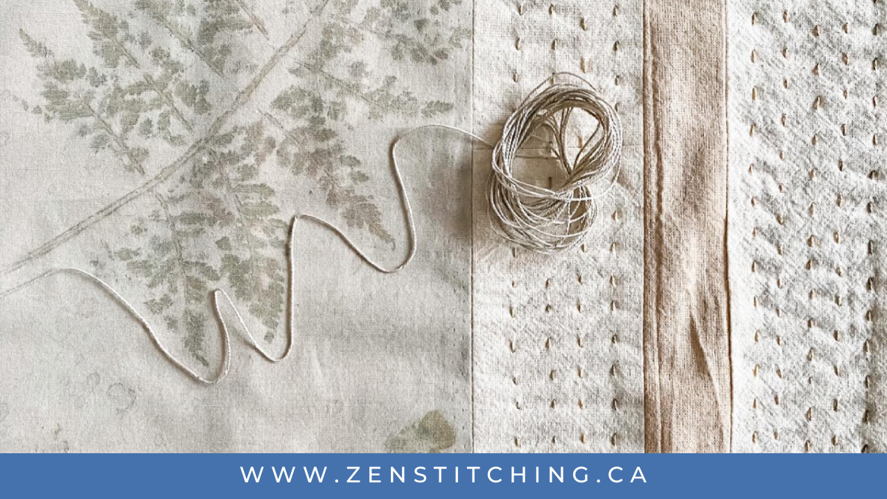 A small ball of thread lays on a natural-coloured background of eco-printed and slow-stitched fabric. The bottom reads 