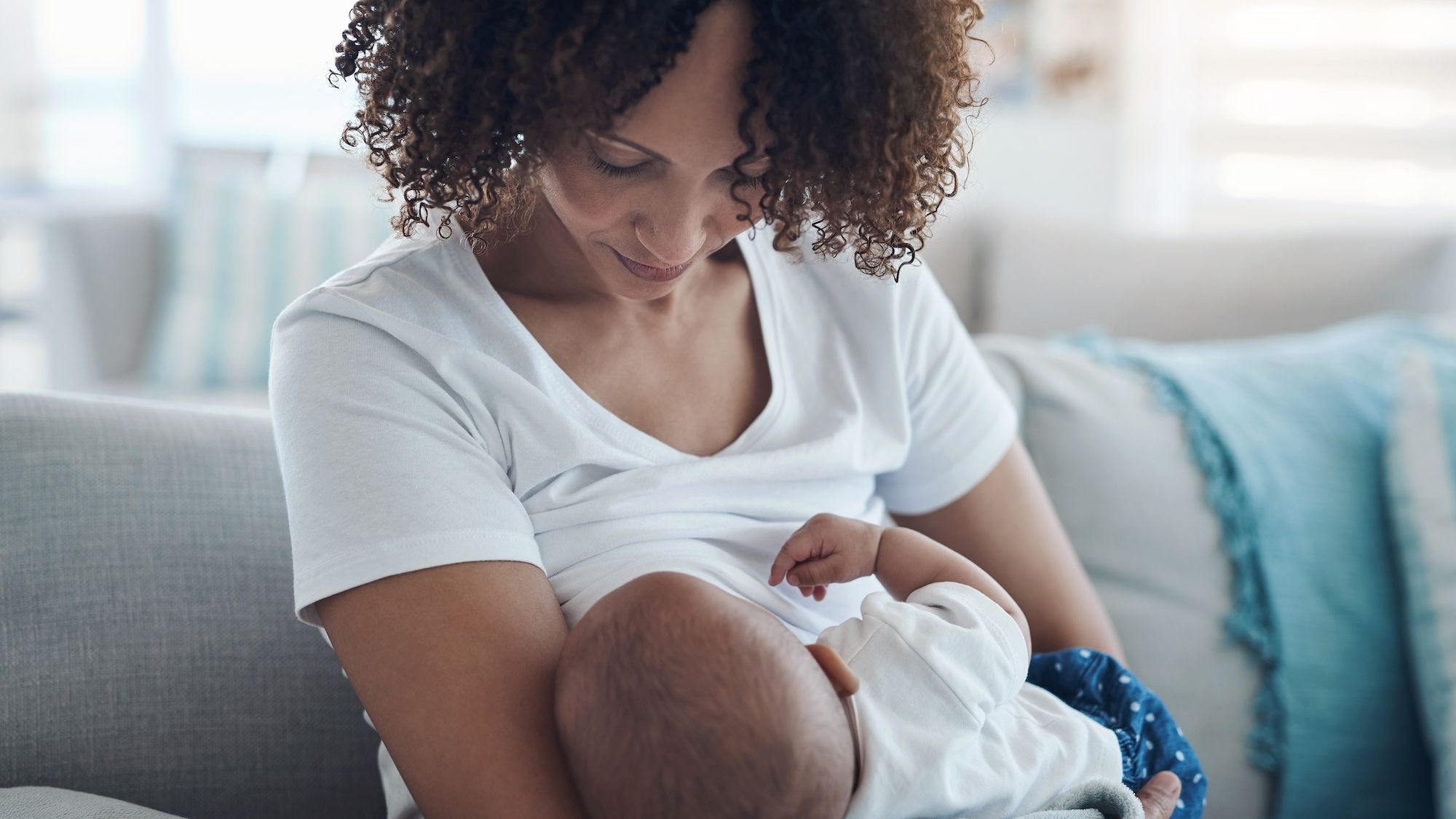 Mother holding their new baby for breast feeding or formula feeding in a bottle.