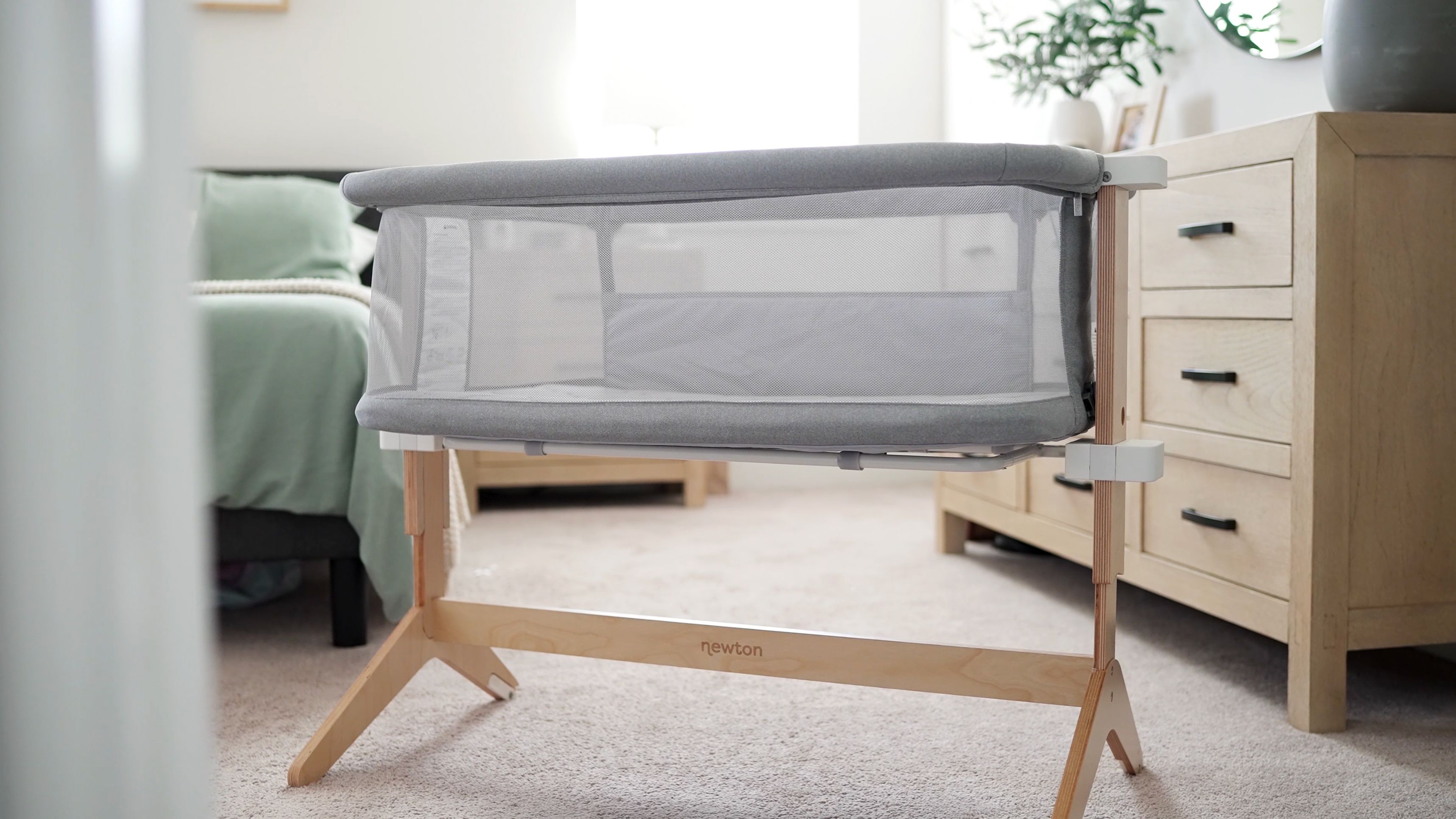 Grey Newton's Baby Bassinet with Mesh Sides.