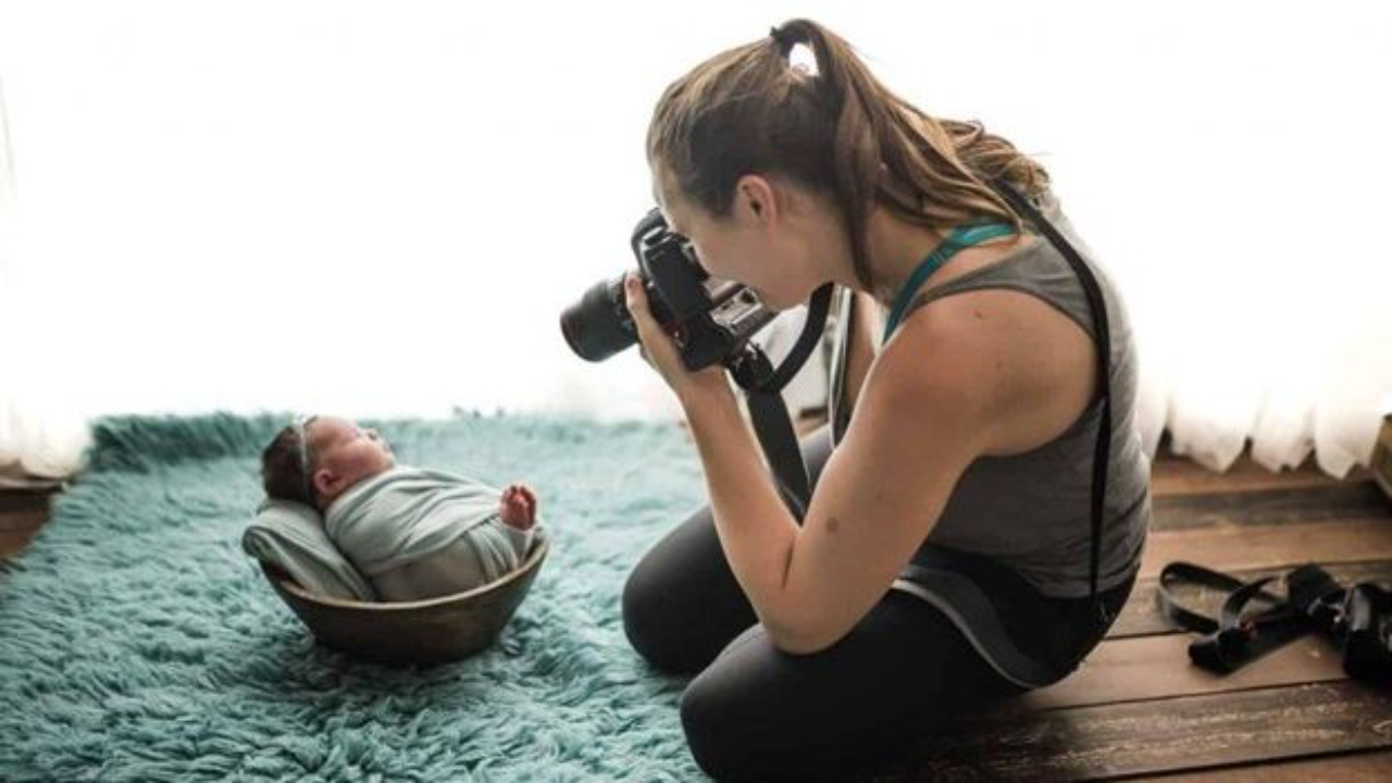 Woman taking a picture of a newborn baby for newborn baby pictures.