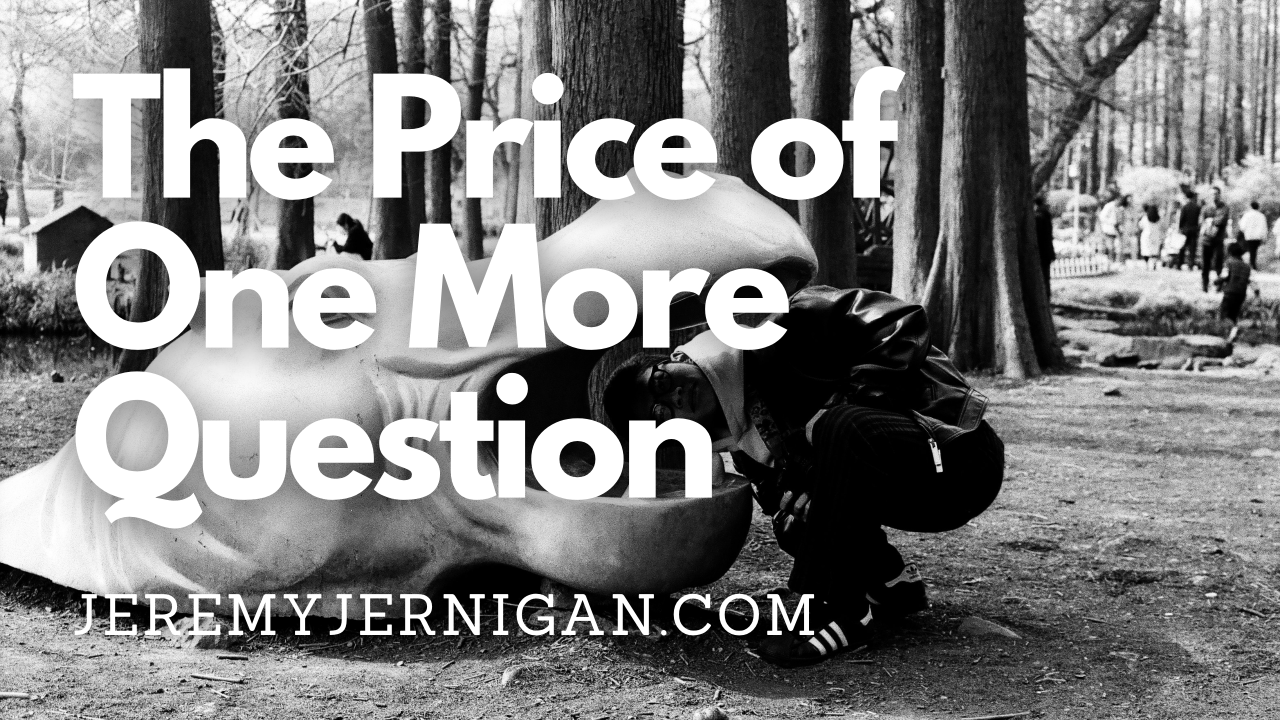 Black and white photo of a person crouching down to examine a large sculpture up close, with trees and park visitors in the background, illustrating the curiosity and close examination explored in the post.