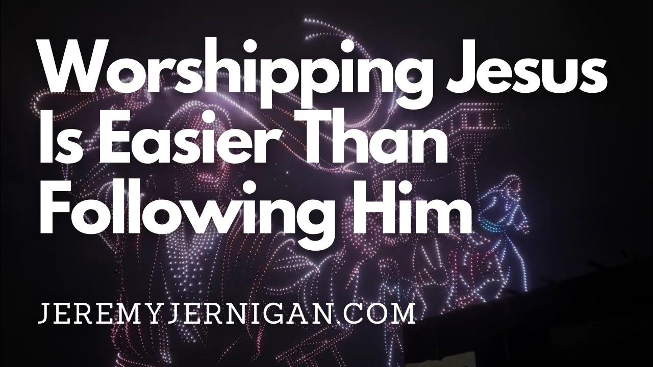 Blog post header image for 'Worshipping Jesus Is Easier Than Following Him' by Jeremy Jernigan, featuring a drone light show display of a cross and religious imagery against a night sky, illustrating the spectacle of modern Christian worship.