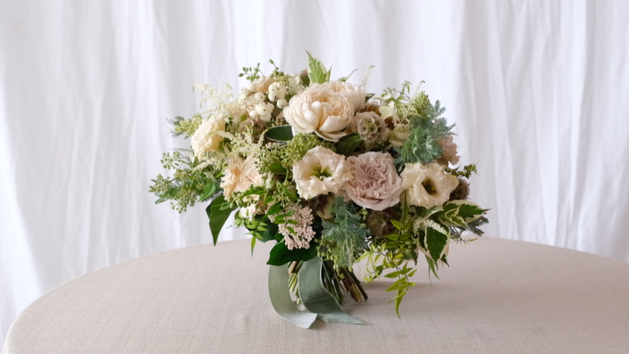 The Garden Bridal Bouquet by Joseph Massie taken from The Wedding Masterclass. Garden style bridal bouquet with soft ivory roses, lisianthus and seasonal foliage in a natural, hand tied design