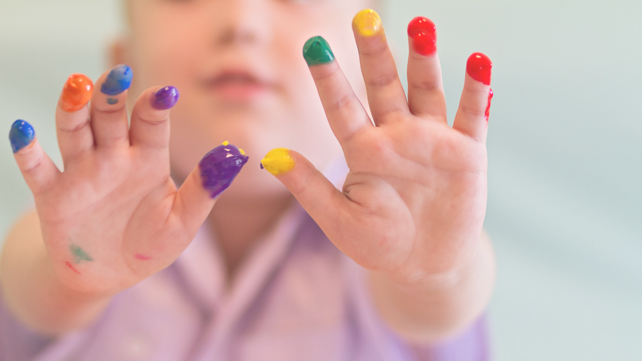Kid Spreading Fingers with Finger Paint - Sign of Subtle Sensory Processing Signal. Kid giving parent a hint before they get to meltdown or sensory overload