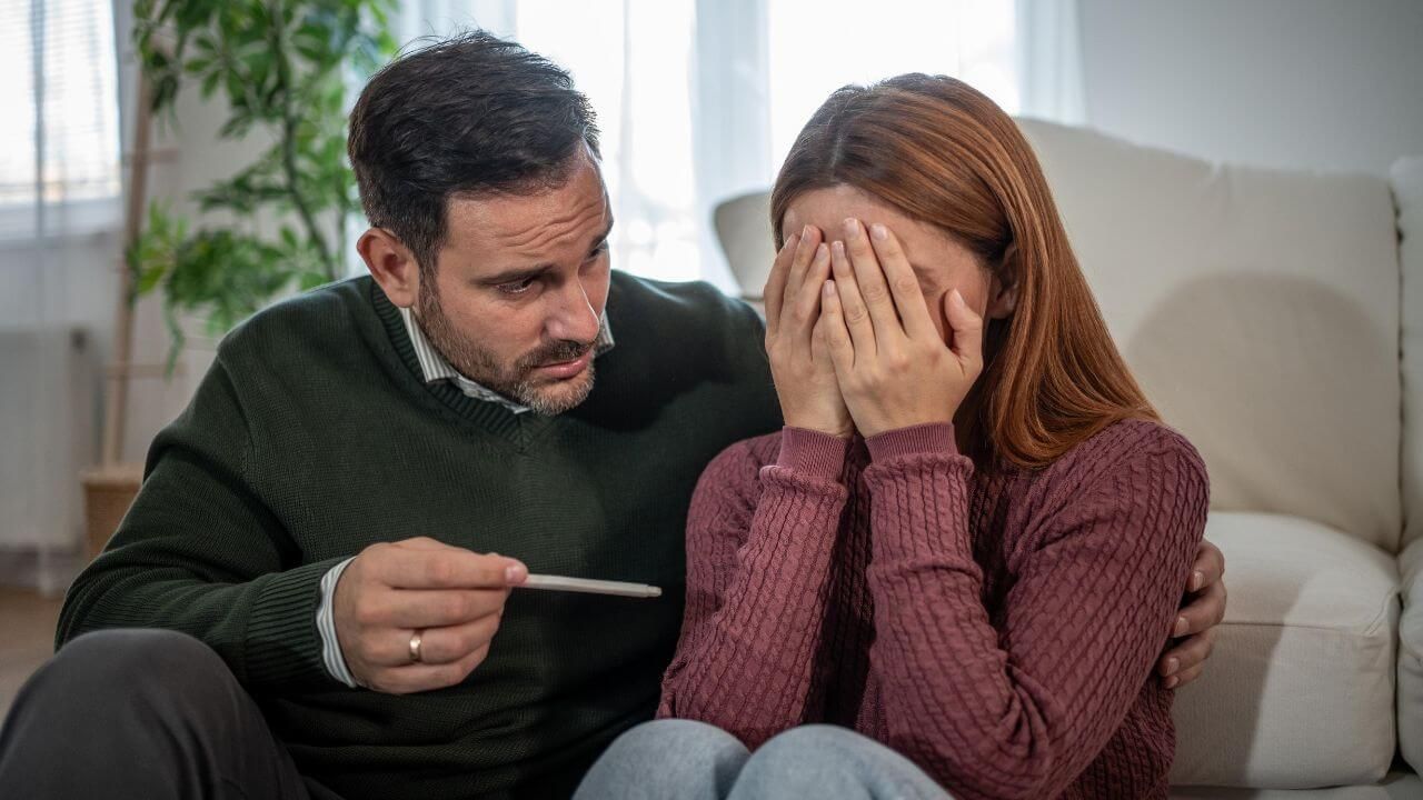 Couple feeling disappointed after a negative pregnancy test while trying to conceive