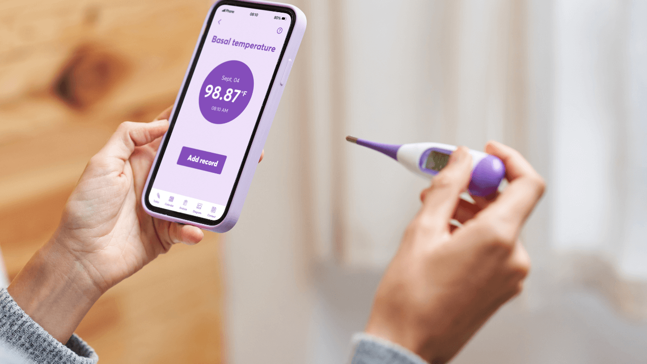 Tracking basal body temperature with a thermometer and fertility app displaying temperature data