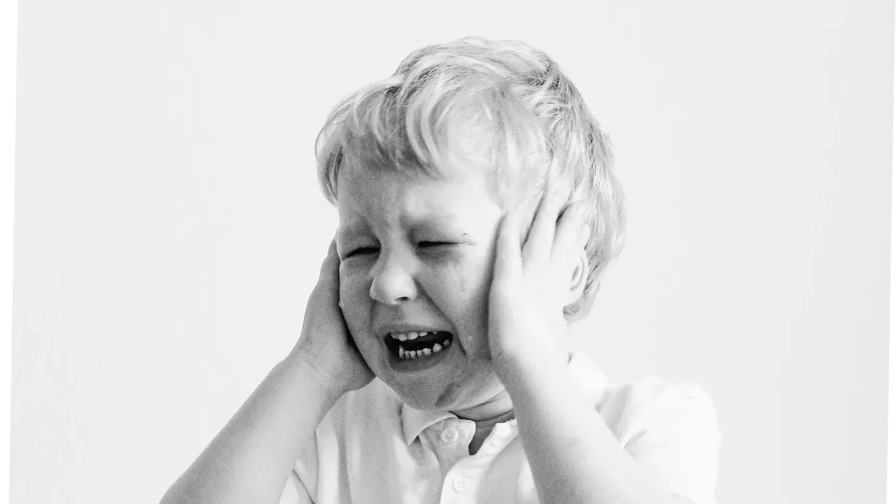 Child holds his ear and crying