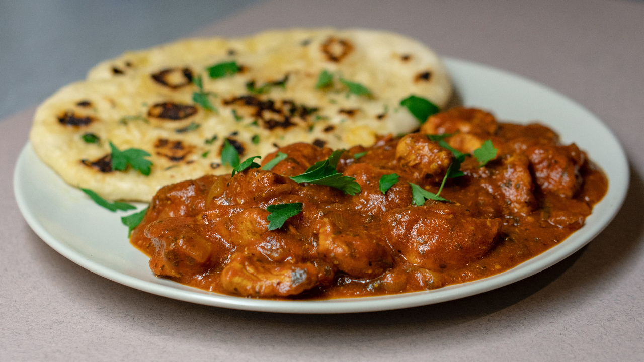 Aromatic Rogan Josh curry in a bowl, garnished with fresh coriander leaves. Tender lamb cooked with spices and yogurt. Perfect with cauliflower rice or Primal Alternative Naan.