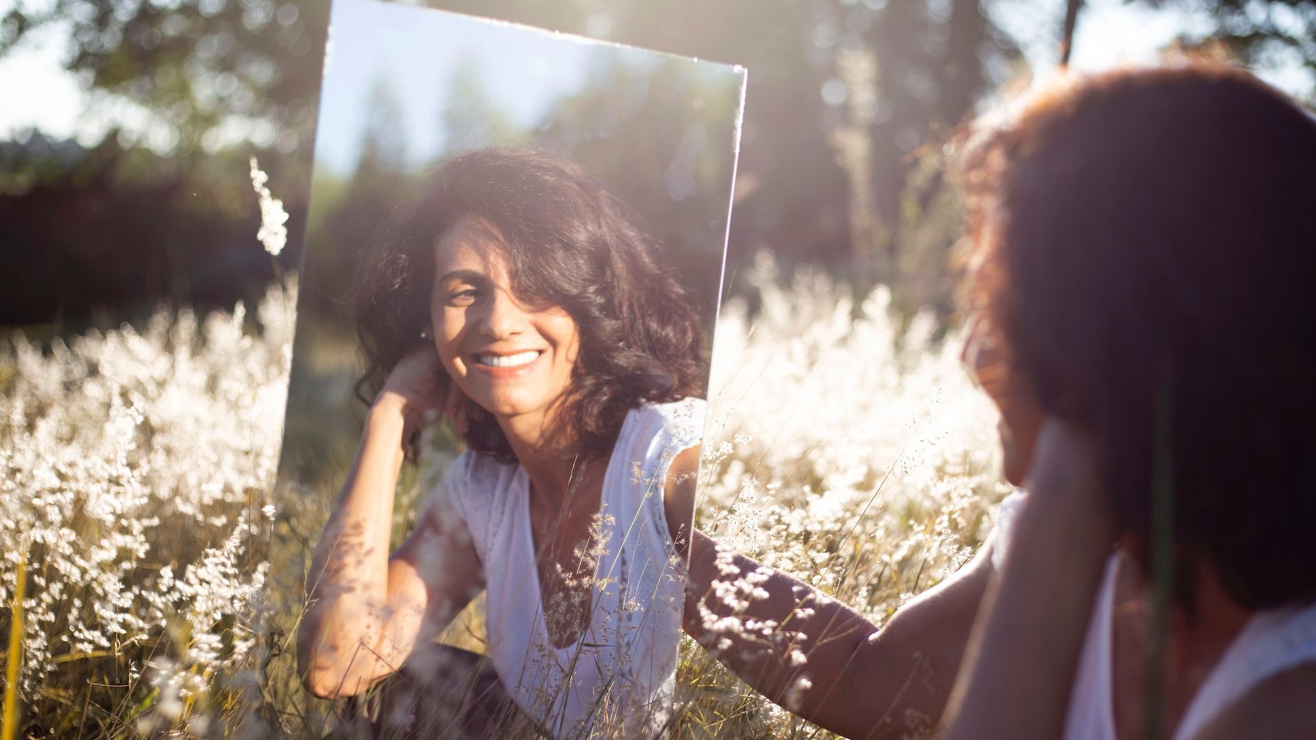 Woman looking in front of the mirror, smiling