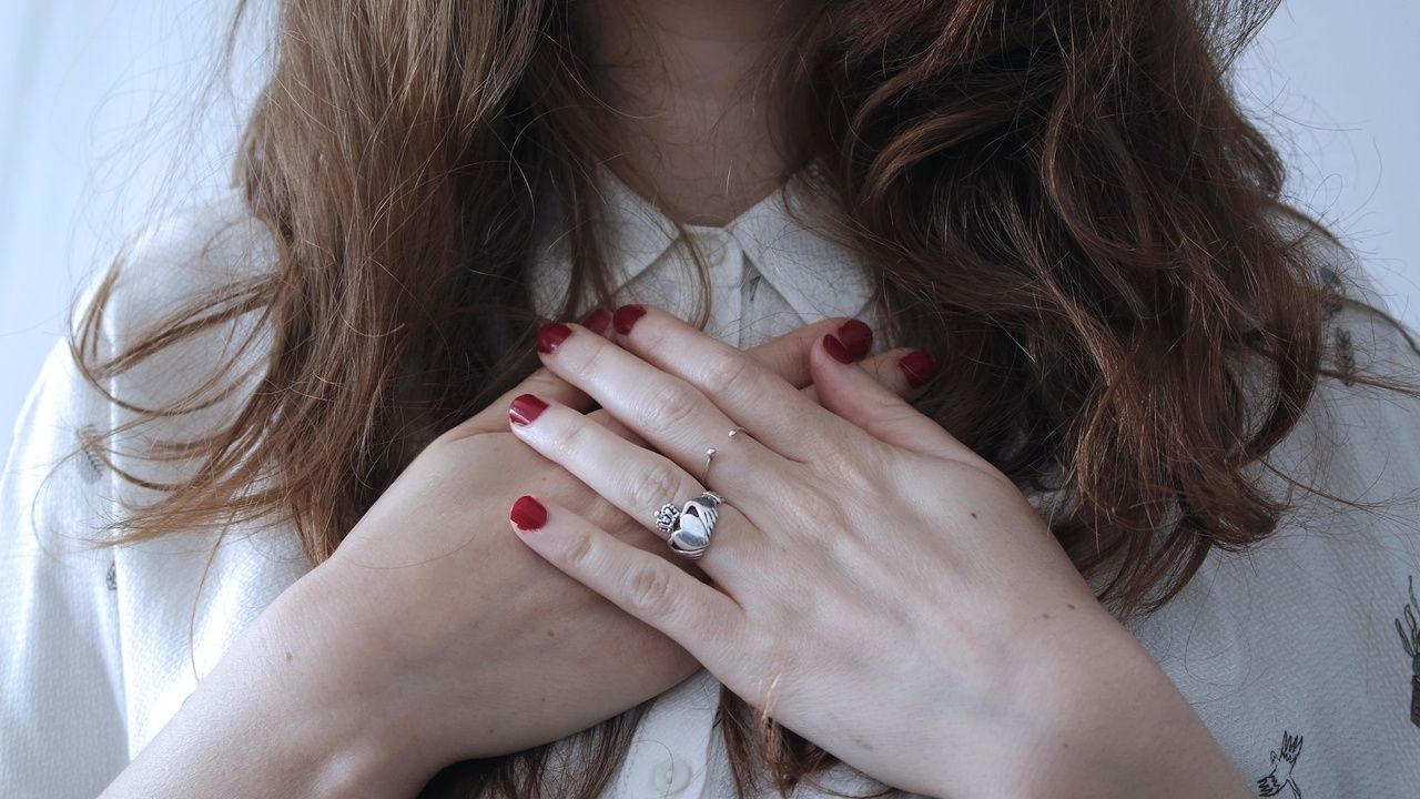 Woman calming intrusive thoughts by putting her hands on her heart