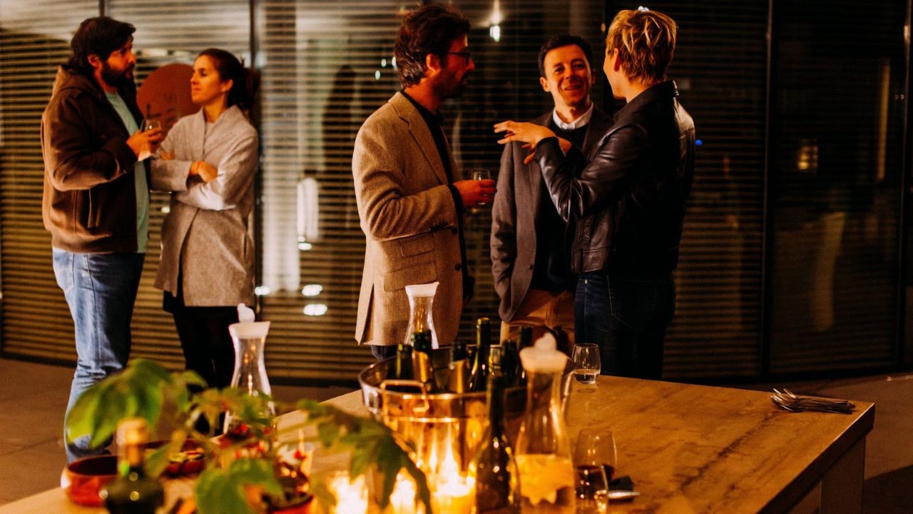 Image is of a group of people standing around at a holiday party. As parents of transgender children we need to set boundaries before we attend holiday events for the sake of our children and ourselves. 