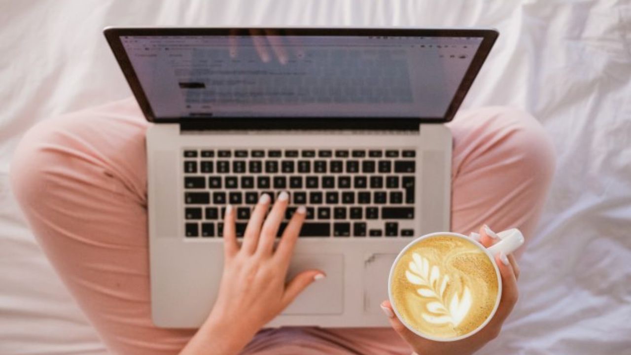 Image is a person sitting on a white sheet with a laptop on their lap and a cup of coffee. All you can see is the legs, the laptop, and the coffee. When our kids come out as transgender, we spend a lot of time looking answers, looking for information, and looking for community. We have to support ourselves so we can support our kids. 