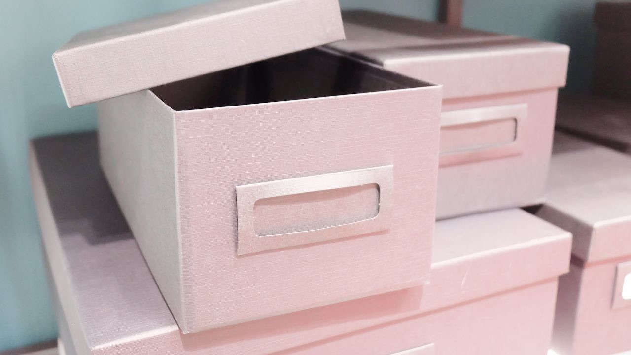 Image is of a stack of pink photo boxes which are good for creating memory boxes of items you want to save from the time before your child came out as transgender. 