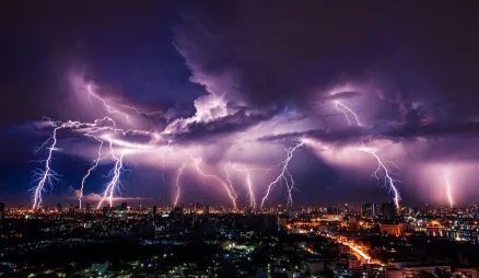 Many bolts of lightning striking a city skyline