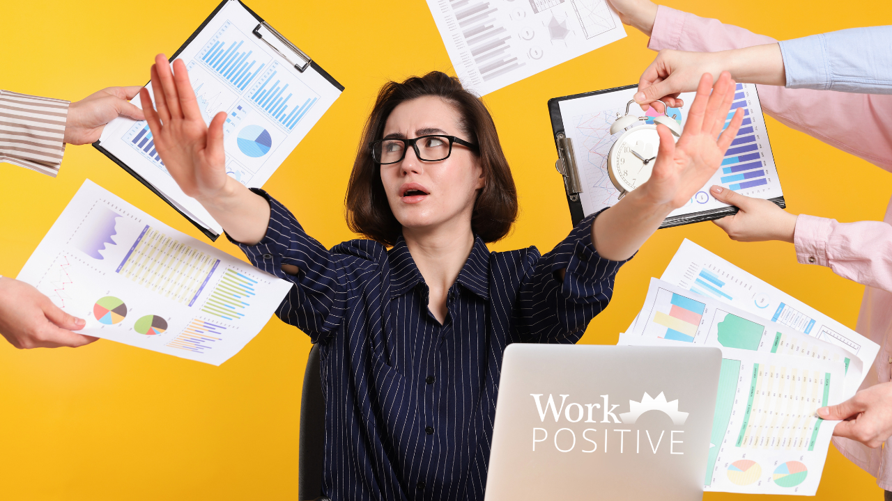 Overwhelmed businesswoman in black striped shirt and glasses with hands raised defensively against bright yellow background, surrounded by multiple hands holding clipboards with charts, graphs, and reports, plus clock showing time pressure, with Work Positive logo on laptop, illustrating workplace chaos from constant change and overwhelming demands.