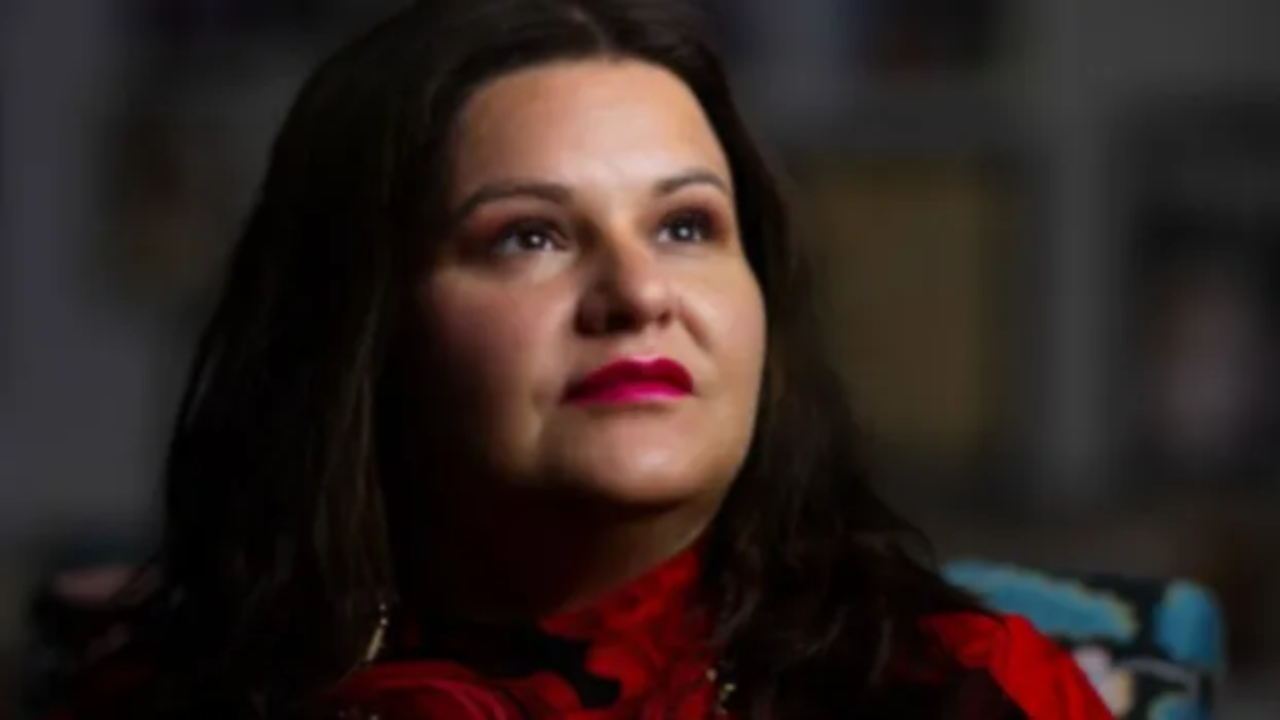 Portrait of Brandi Morin in red, photographed with strength and reflection.