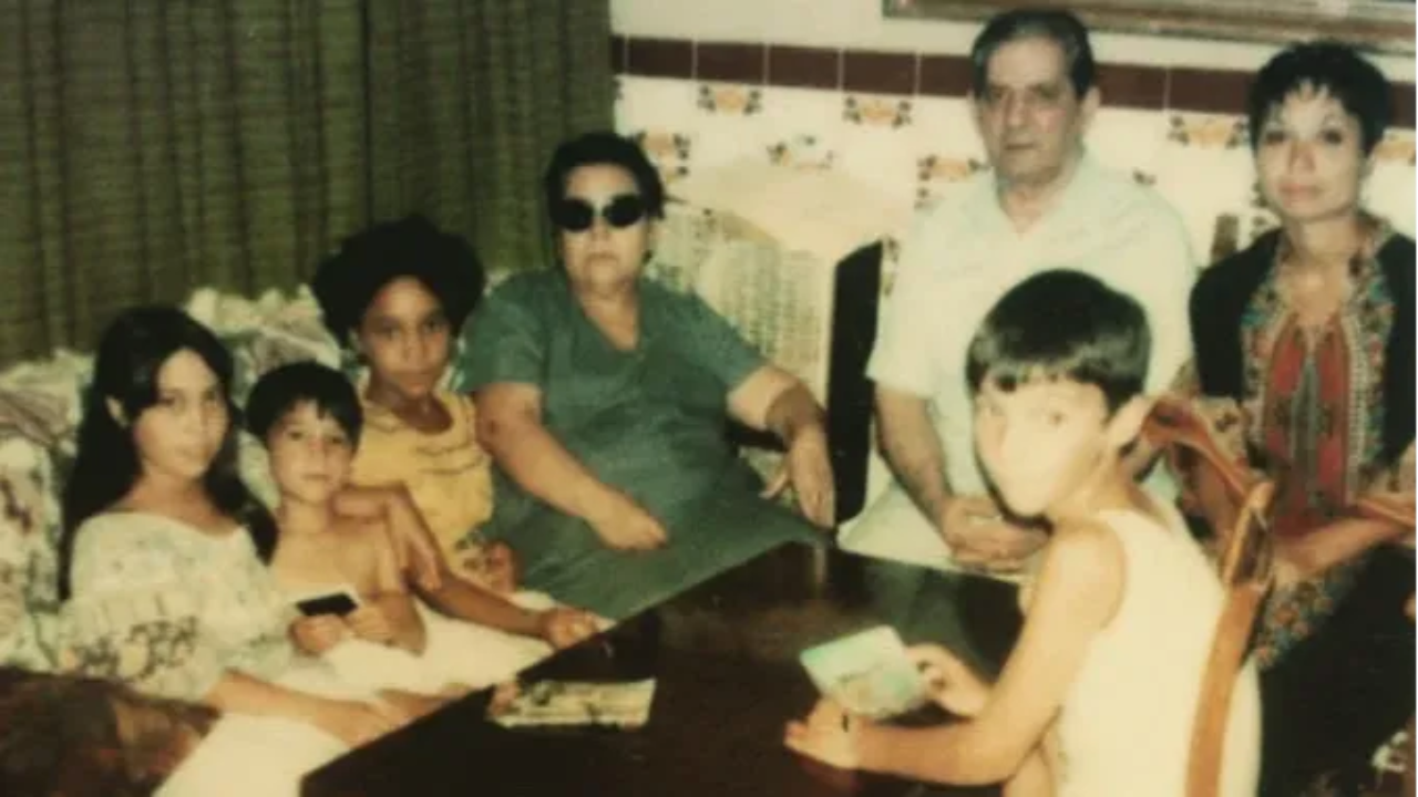 My siblings and me sitting in living room of my grandparents' home in Sevilla Spain, with our mother seated next to her father. Joaquin is seated in a chair in the foreground of the photo. 