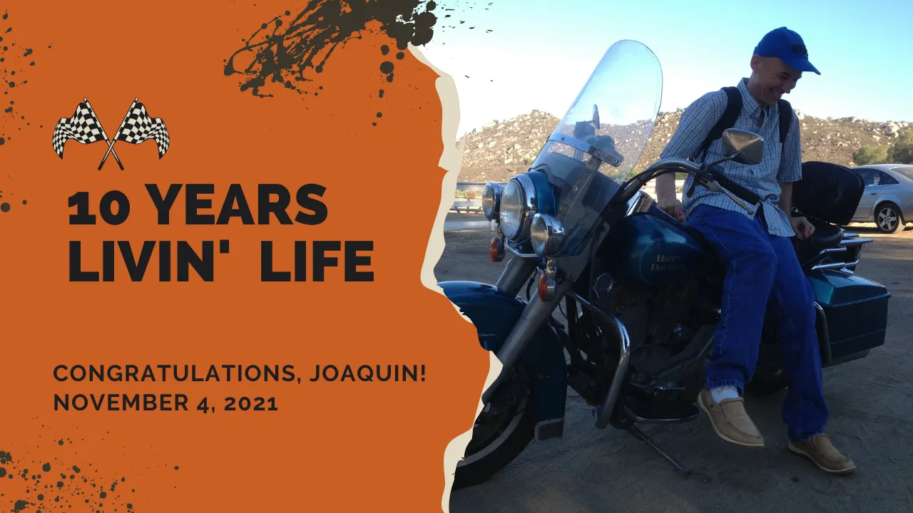 Image description: Joaquín happily sits side-saddle style on a parked Harley-Davidson. He wears casual clothes and a beaming smile on his face. Text says: 10 years livin’ life. Congratulations Joaquin! November 4, 2021.