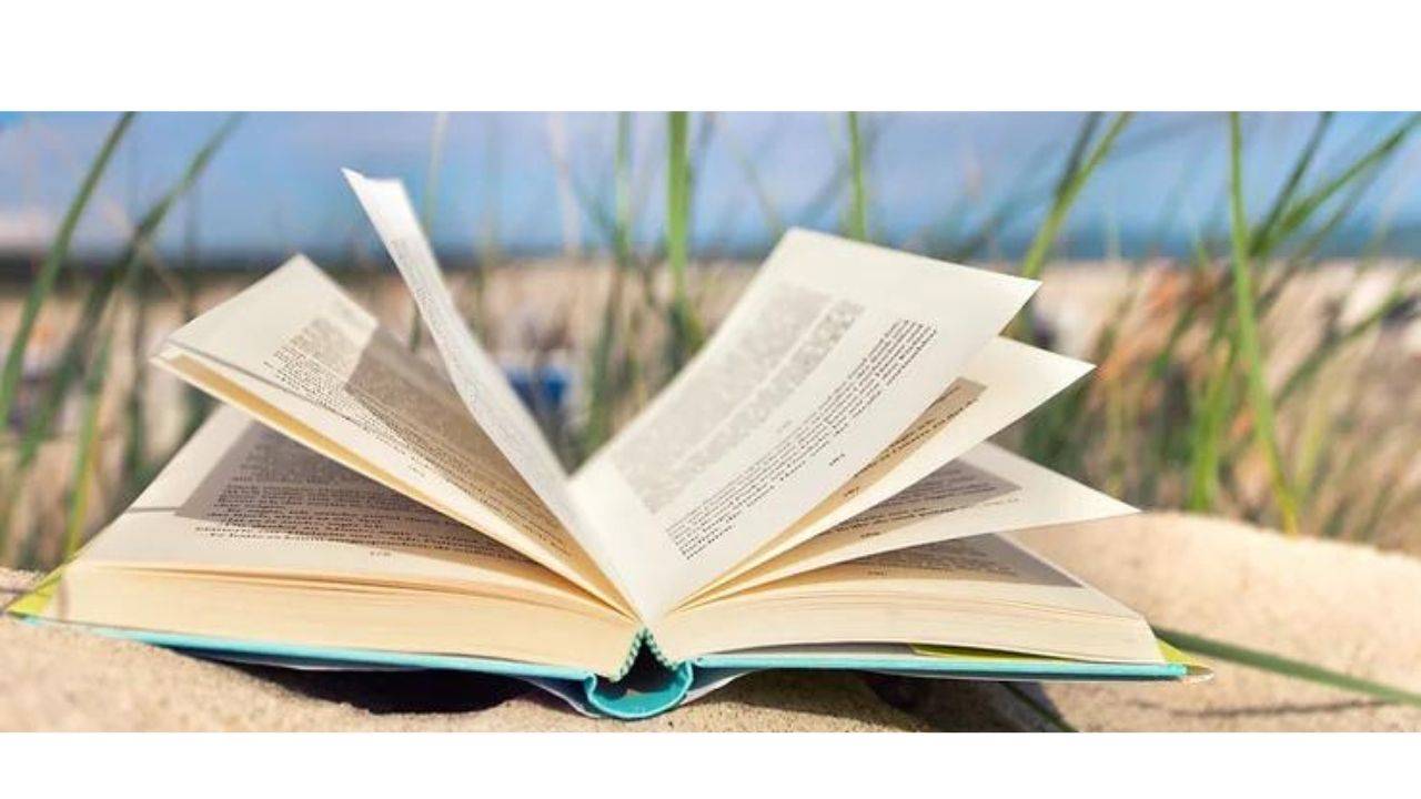 book open on beach sand