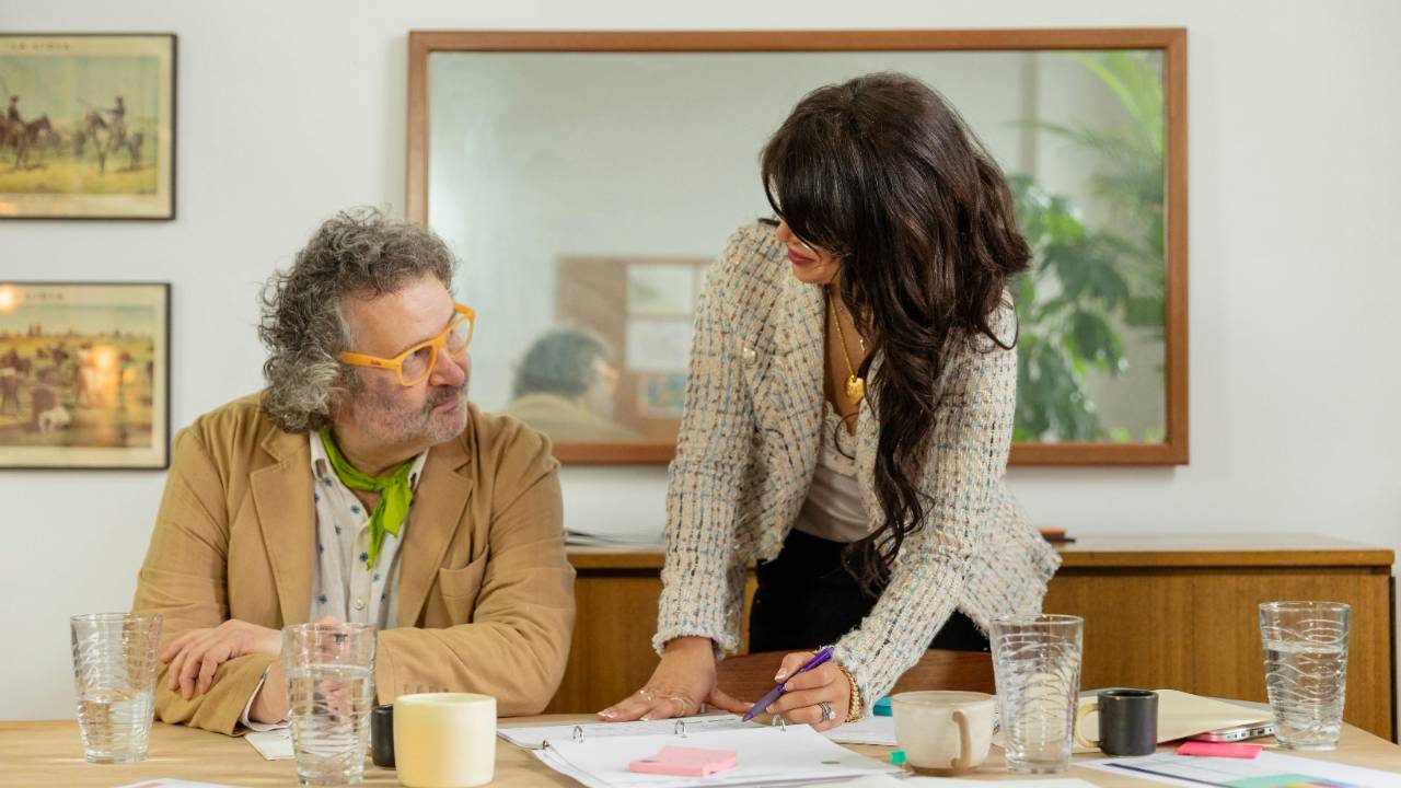 creative project manager reviewing documents with team at conference table modern office