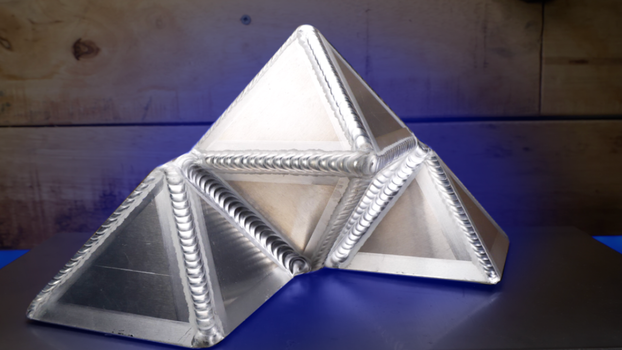 Aluminum pyramid sculpture made from TIG welded triangular panels.