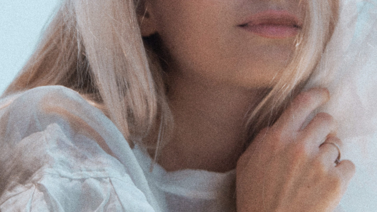 Soft close-up of a woman touching her hair, symbolizing calm feminine presence that helps reframe a man’s withdrawal.