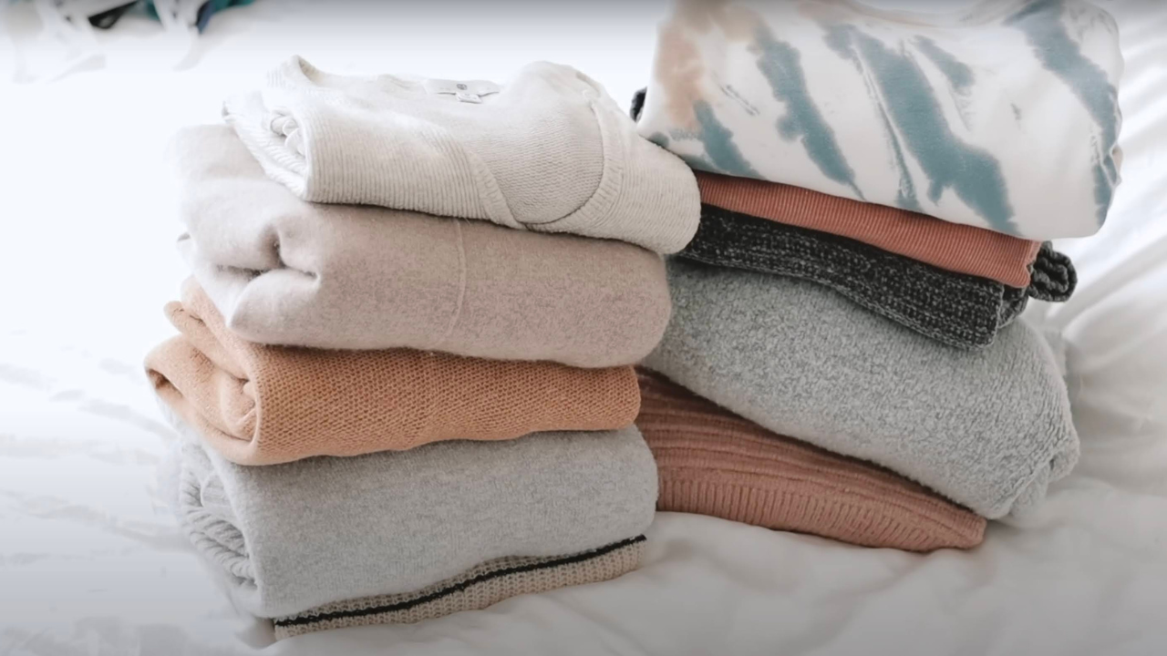 Clothes emptied from a closet and sorted into keep and donate piles