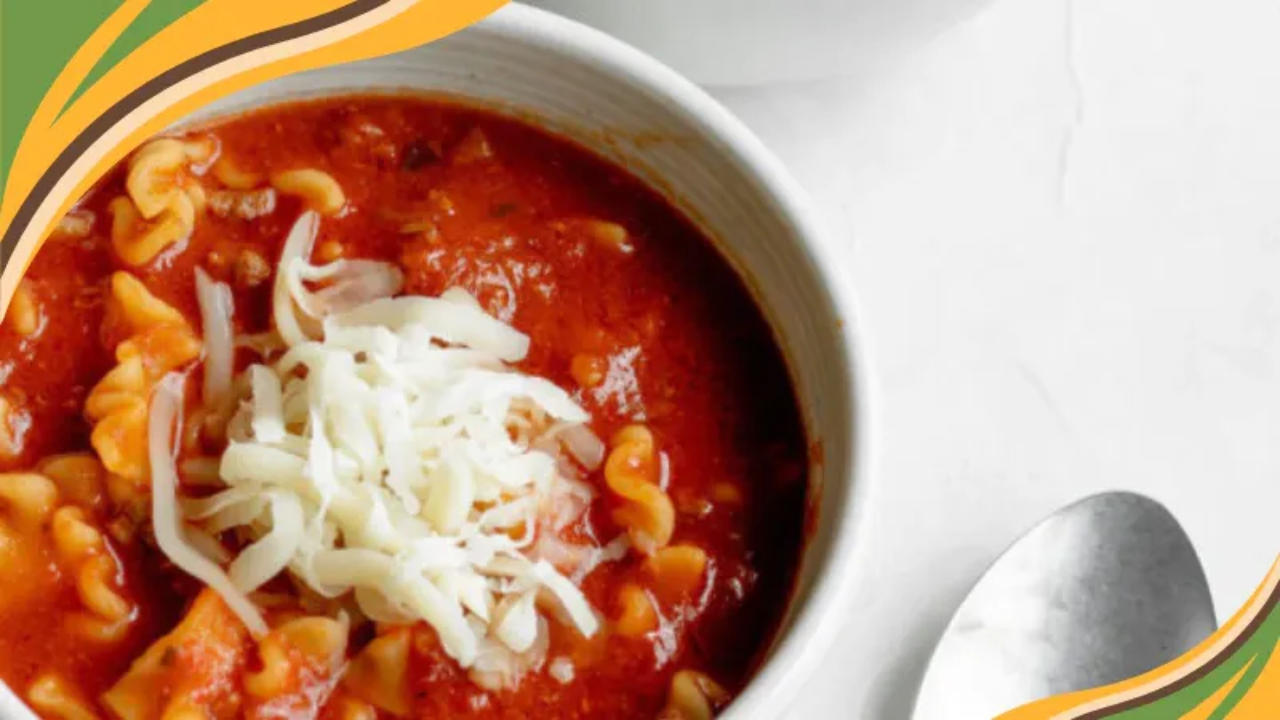 Bowl of hearty lasagna soup topped with shredded cheese in a rich tomato broth, perfect for a cozy comfort meal.