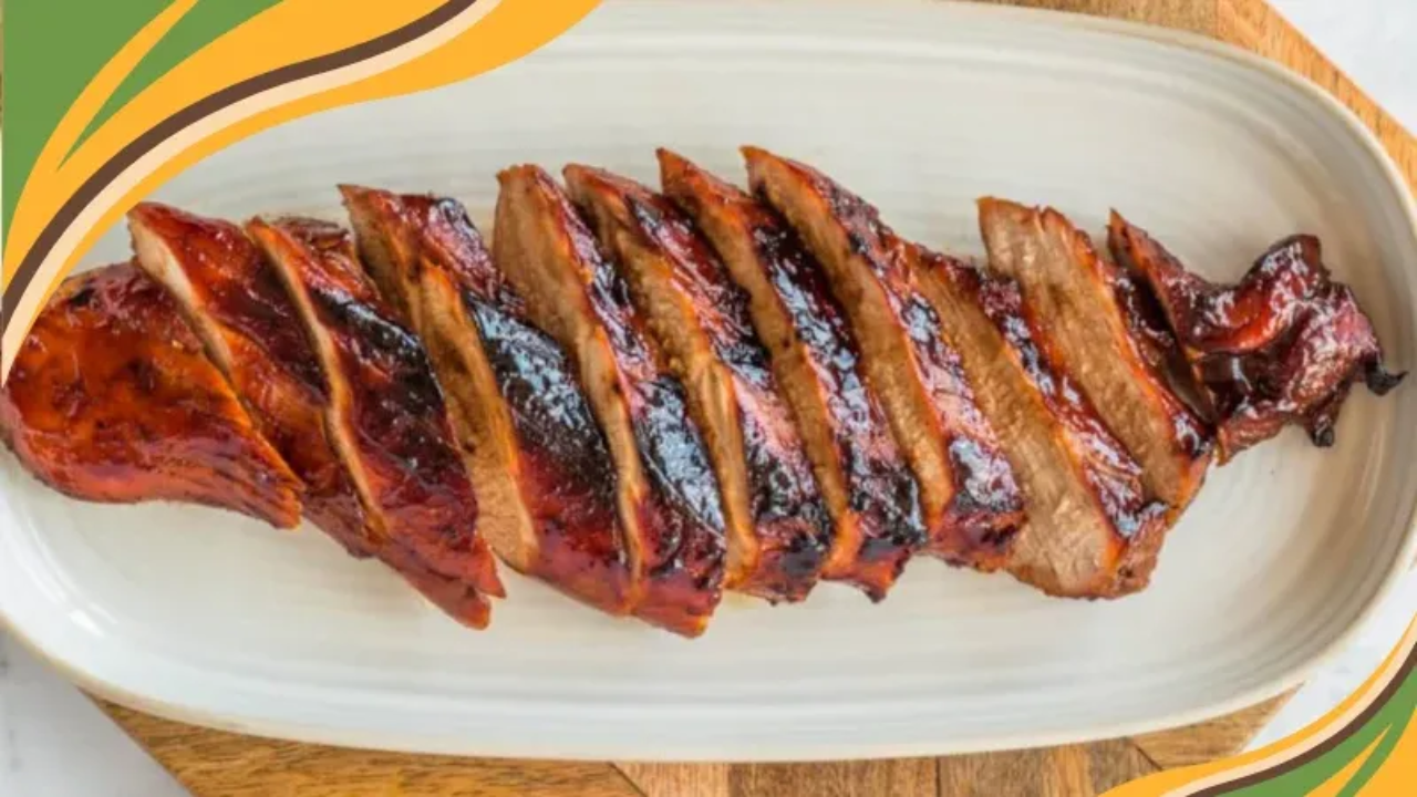 A platter of sliced Chinese style barbecue pork with a glossy finish. The pork is arranged neatly on a white dish, highlighting the caramelized edges and rich color.  