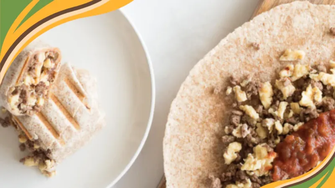 Beef and egg breakfast burrito made with extra lean ground beef, scrambled eggs, and salsa wrapped in a whole wheat tortilla, shown sliced on a plate for a quick, protein-rich morning meal.