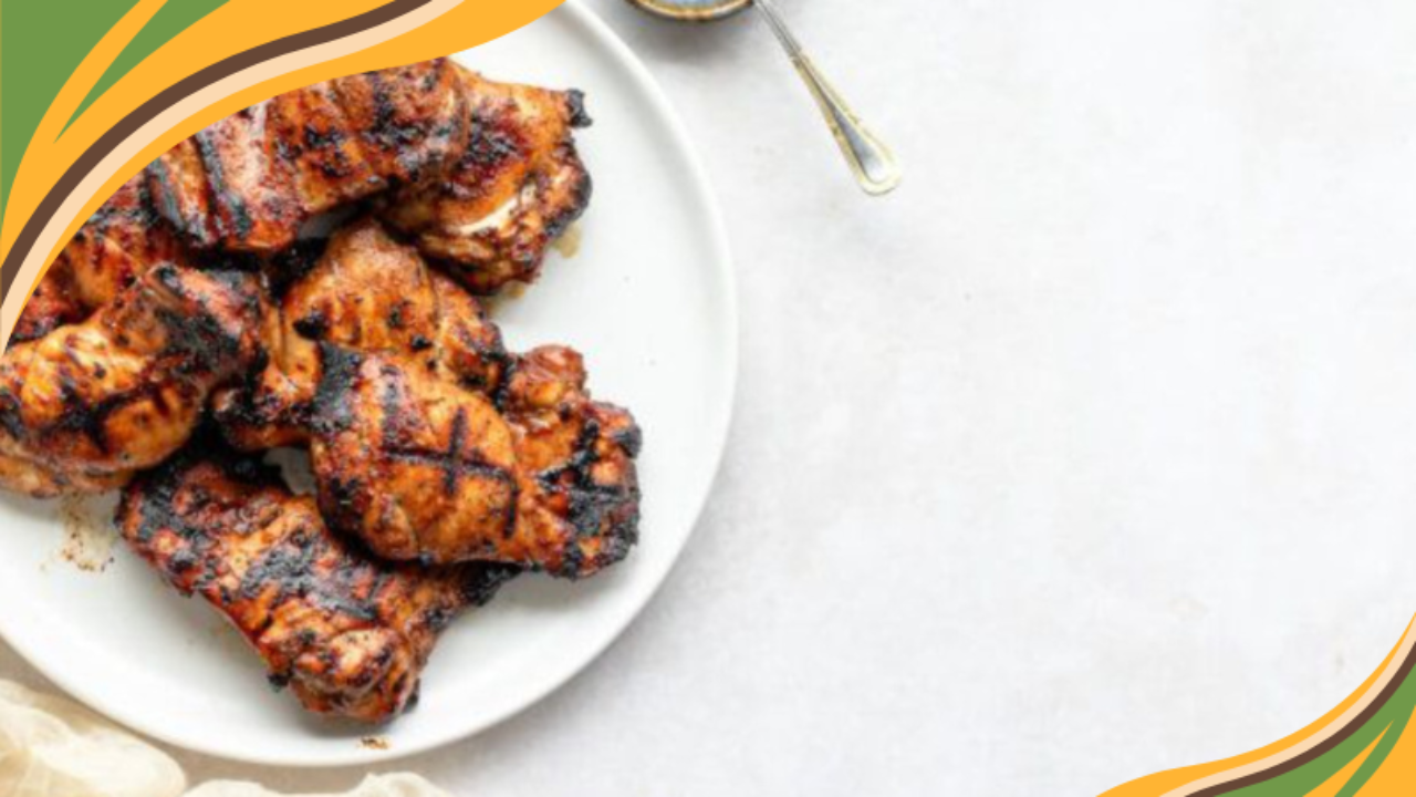 Grilled BBQ chicken thighs with char marks served on a white plate, perfect for a summer dinner or backyard cookout.
