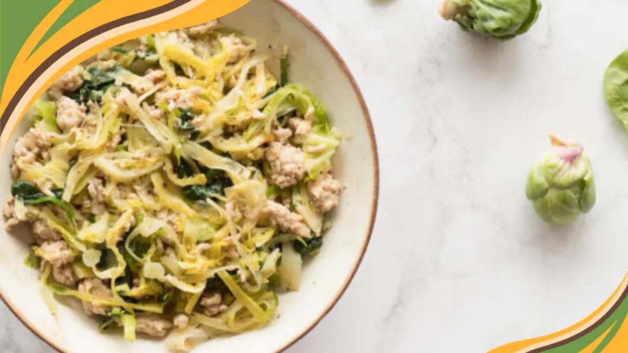 Bowl of sauteed garlic chicken and greens made with ground chicken, shredded cabbage, Brussels sprouts, leeks, and spinach, served as a simple real food meal.