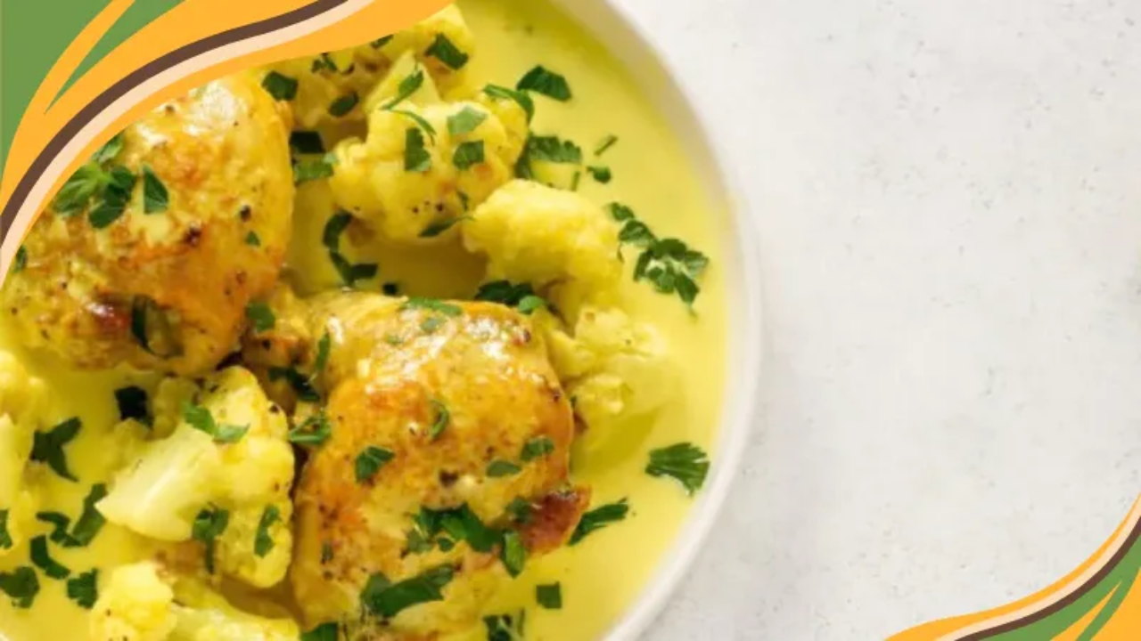 Creamy turmeric chicken with roasted cauliflower, garnished with fresh parsley, served in a vibrant yellow sauce.