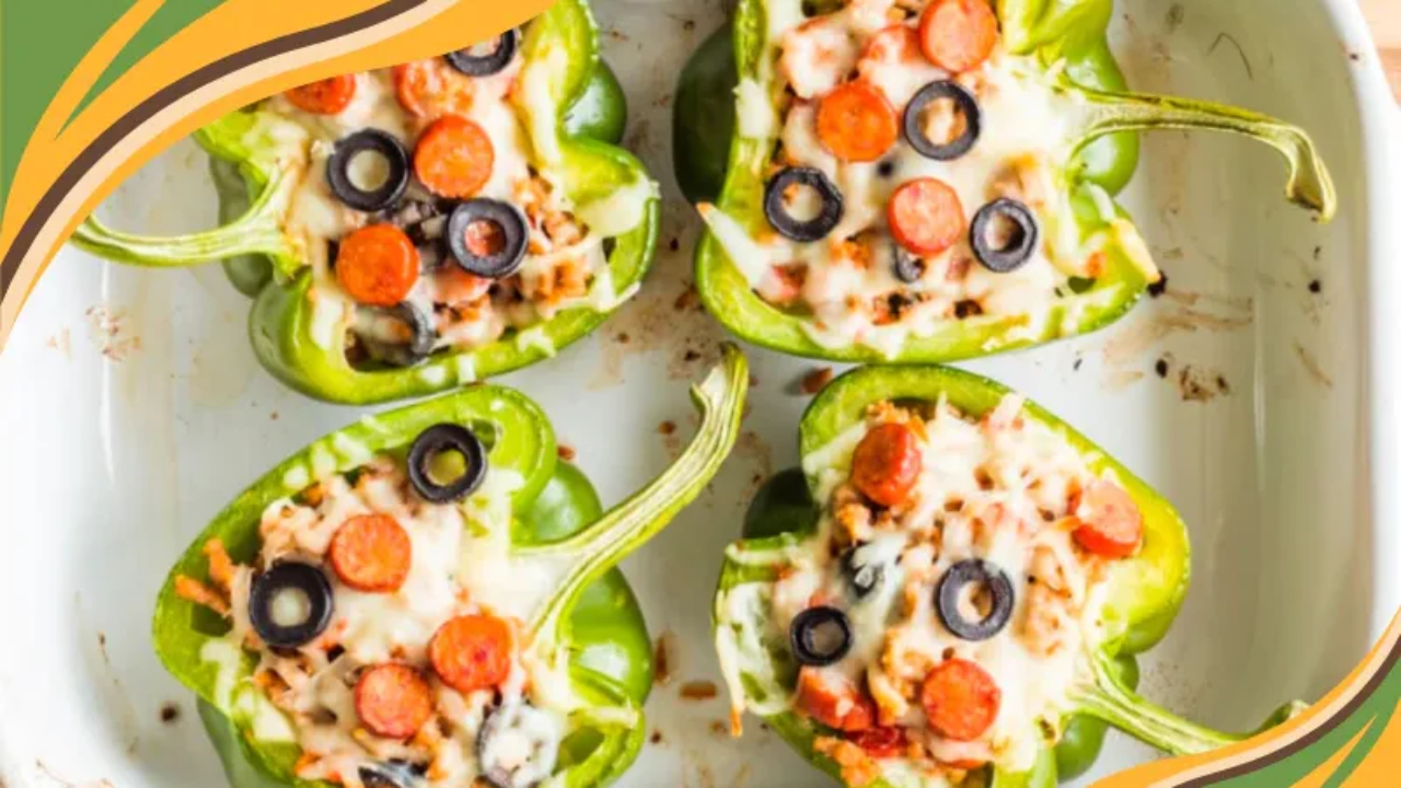 Four green bell pepper halves filled with ground turkey, melted mozzarella, mini pepperoni slices, and black olives, arranged in a white baking dish on a light surface with a white and gray striped kitchen towel.