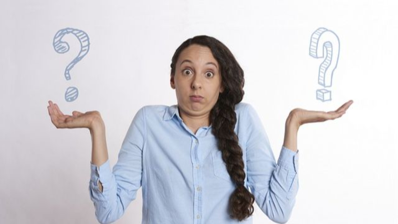 Woman confused with two question marks, one in each hand