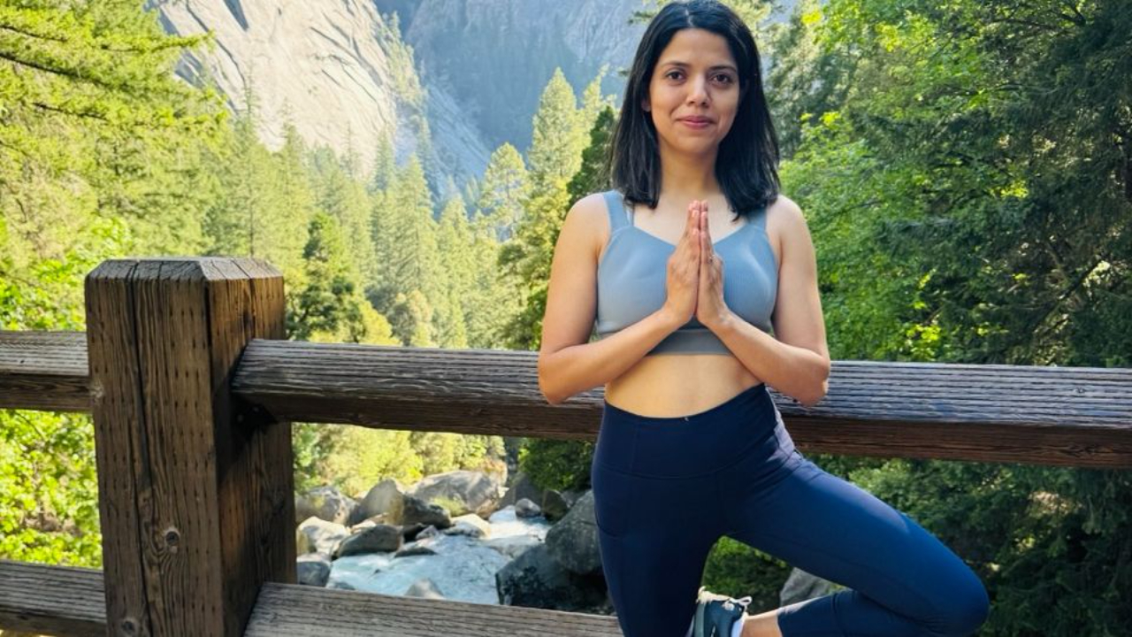 Woman standing in tree pose hands in prayer
