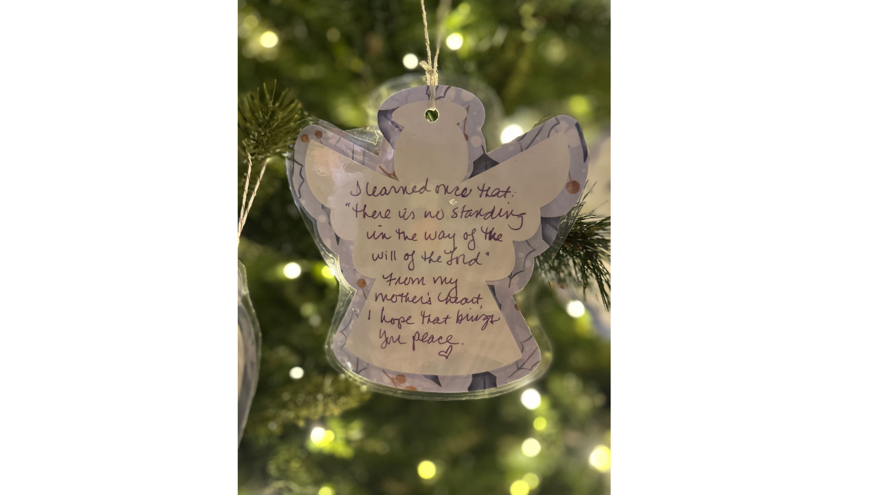 Handwritten angel ornament hanging on a Christmas tree, symbolizing hope and God’s presence during a hard season.