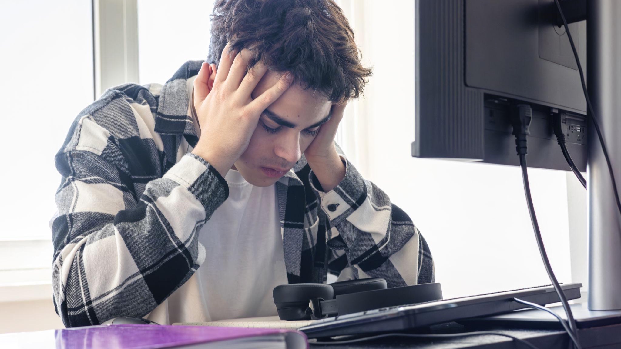 young adult struggling in college feeling stressed studying at desk