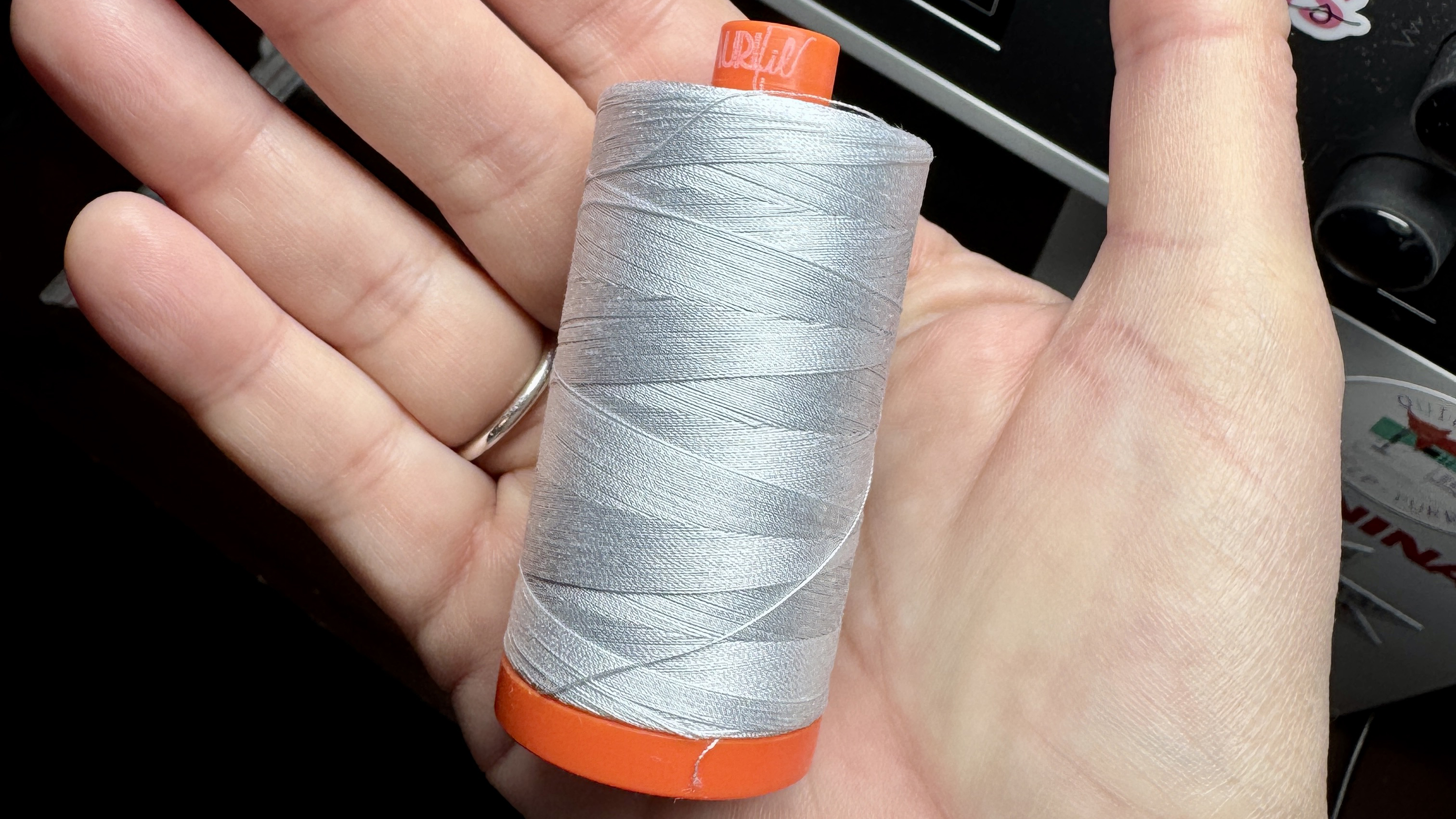 a spool of Aurifil 50 weight thread in Dove Gray