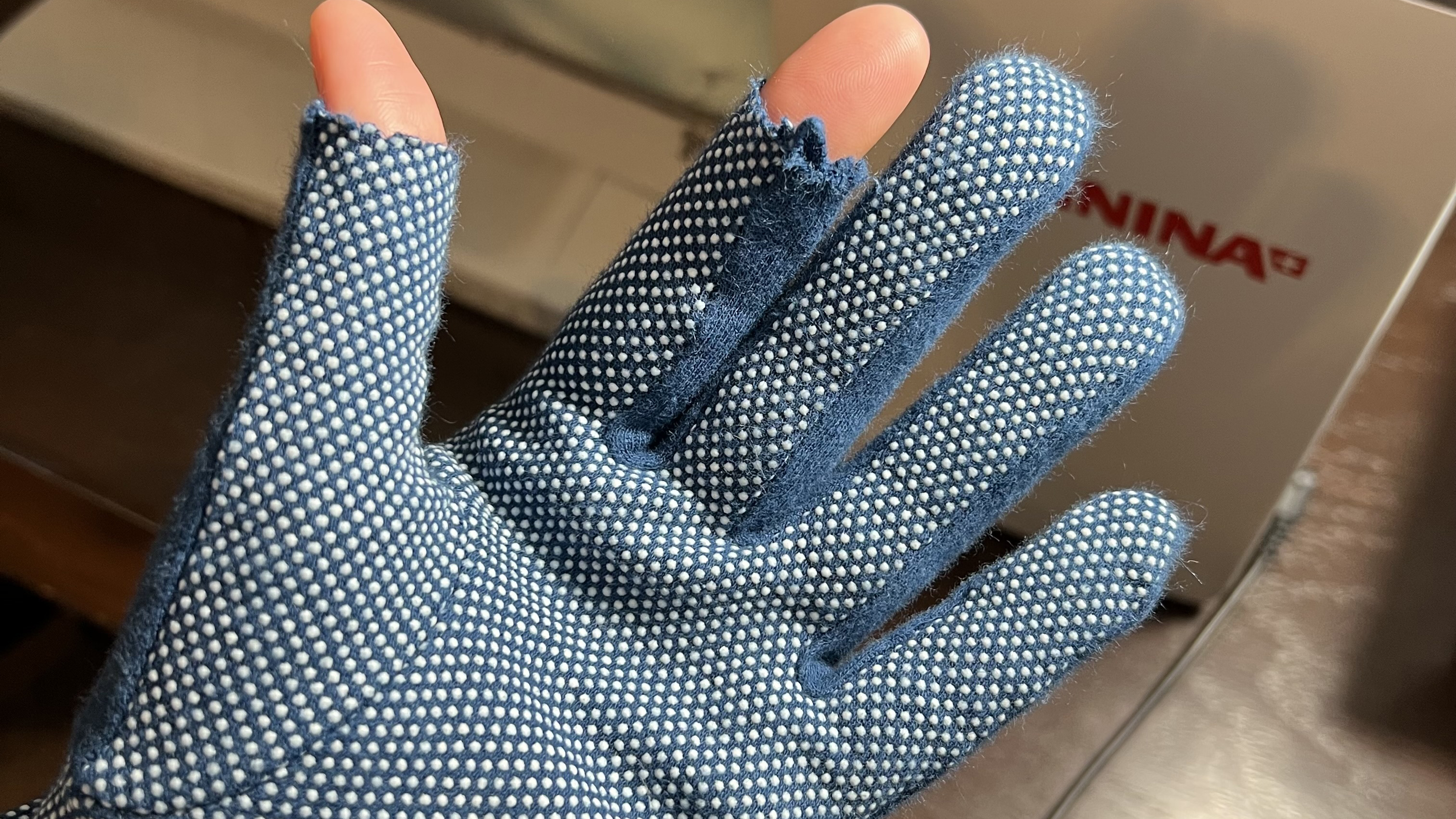 hand wearing a grippy glove for free motion quilting