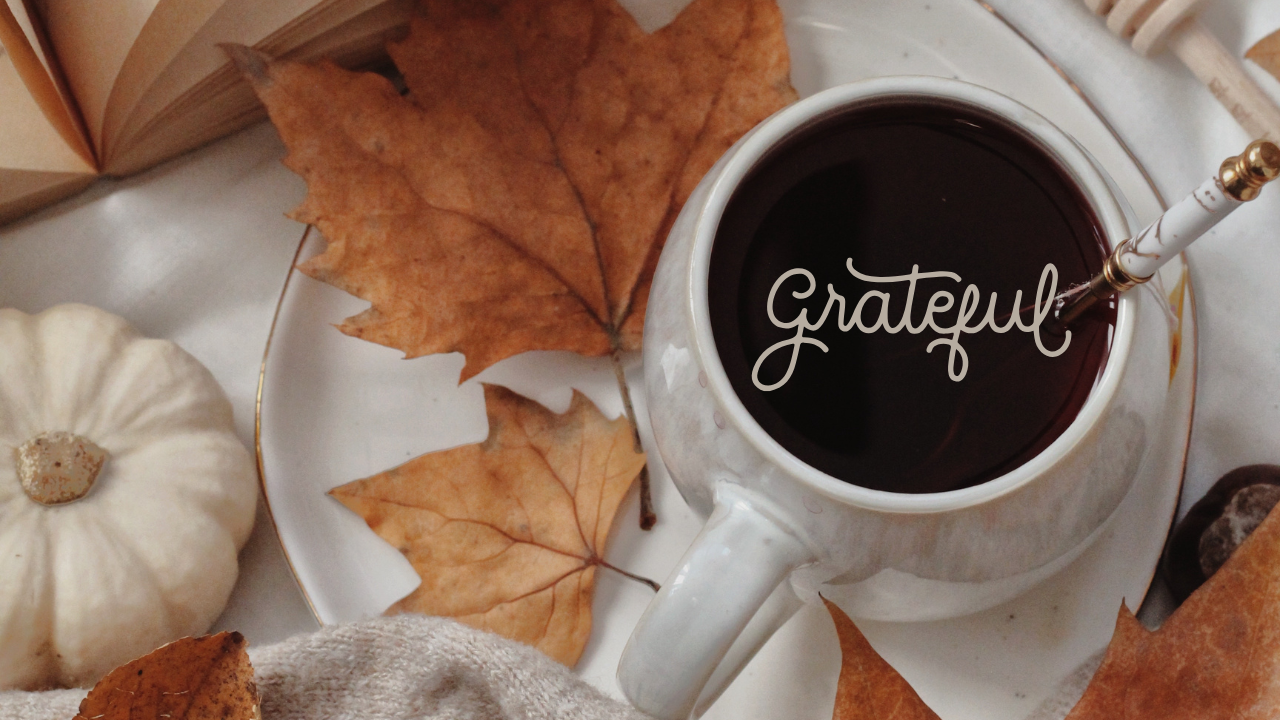 fall scenery of leaves, pumpkins, and a cup of coffee with the overlay word "grateful"