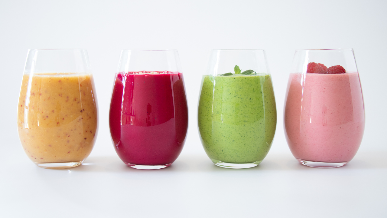 4 different flavored smoothies lined up in glass cups