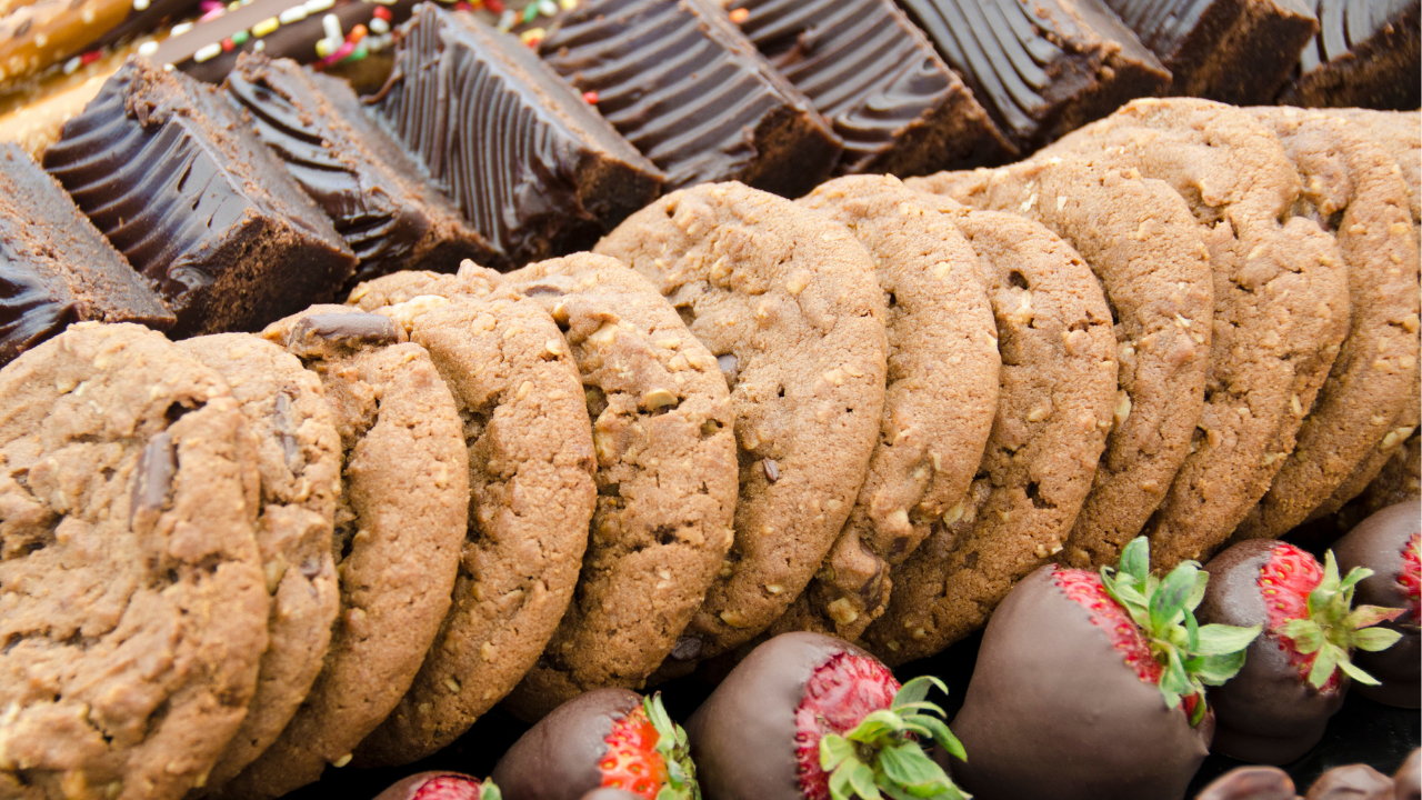 platter of holiday treats like cookies, fudge bars, and chocolate covered strawberries