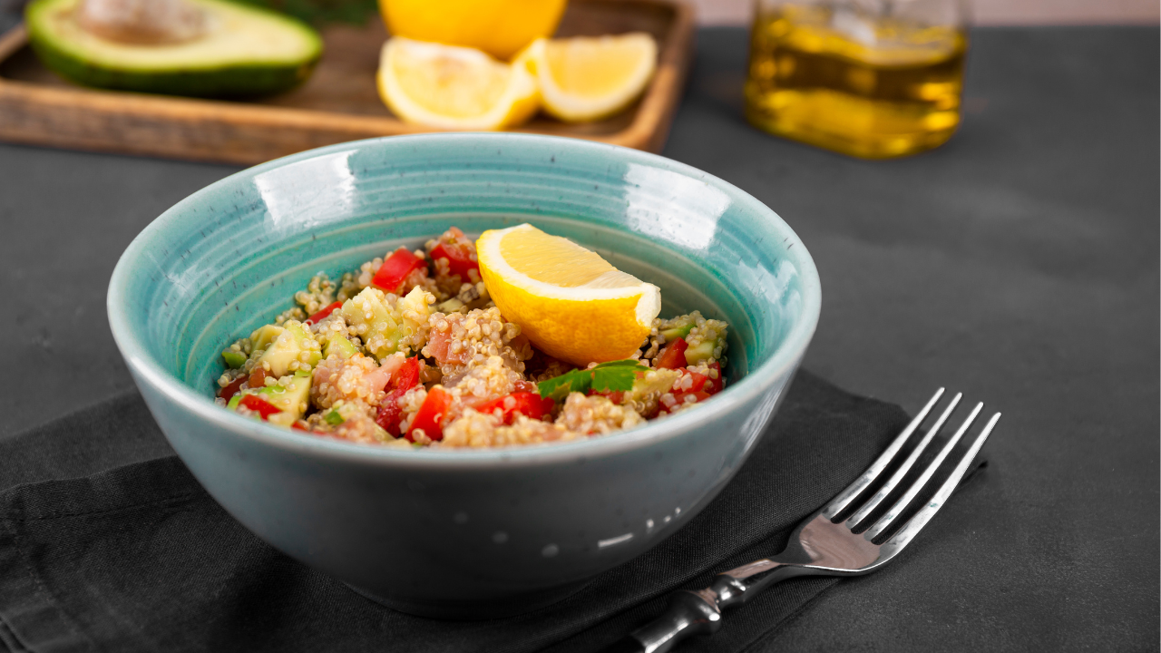 Salmon and Quinoa bowl with veggies garnished with a lemon wedge