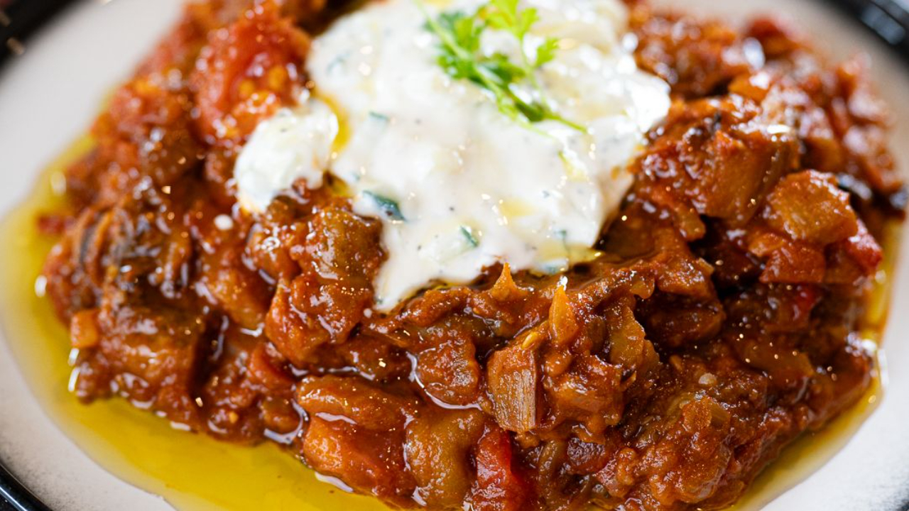 zaalouk moroccan aubergine dip in bowl with olive oil drizzle and fresh herb and youghurt