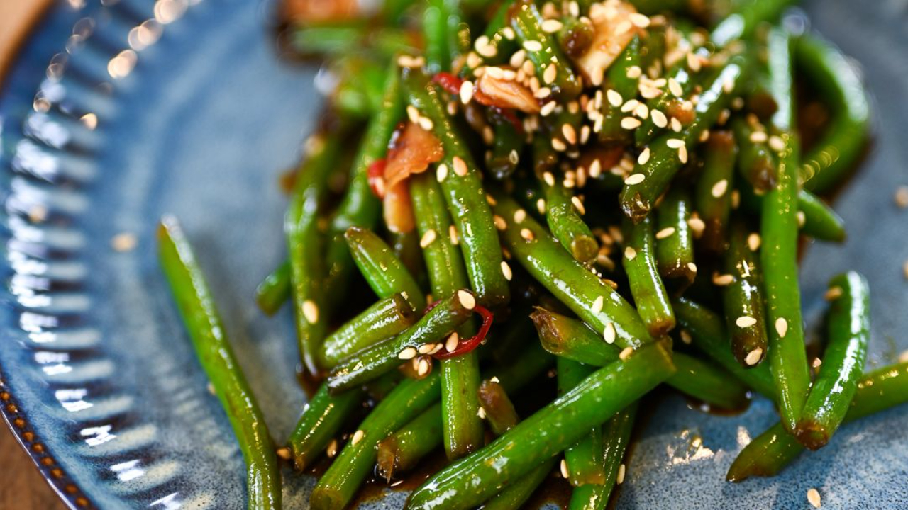 asian style green beans with garlic chilli and sesame seeds on a plate